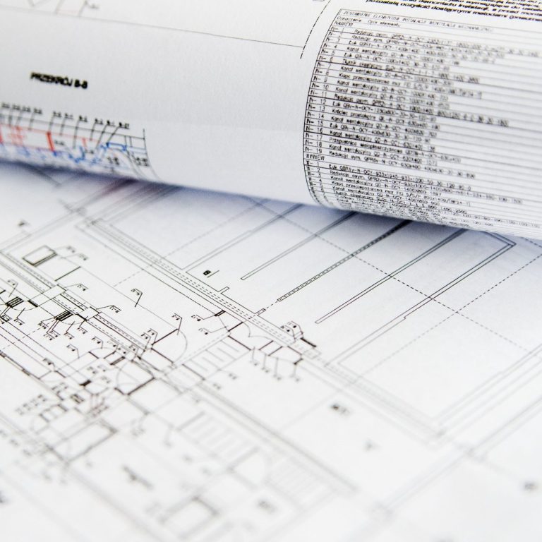 Dokumentation und CE Unterstützung Technische Zeichnungen und Pläne auf gerolltem Papier, teilweise sichtbar.